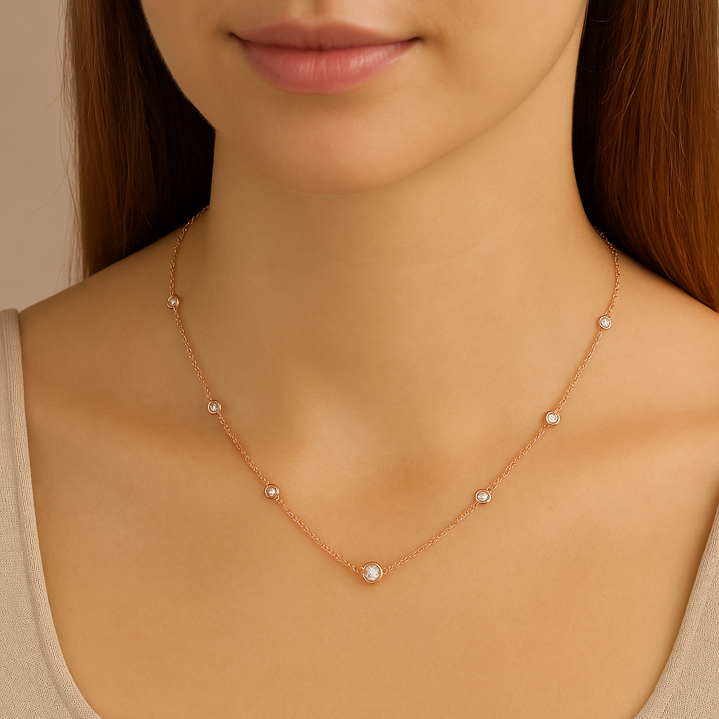 Rose gold necklace with small diamonds on a model against a neutral background