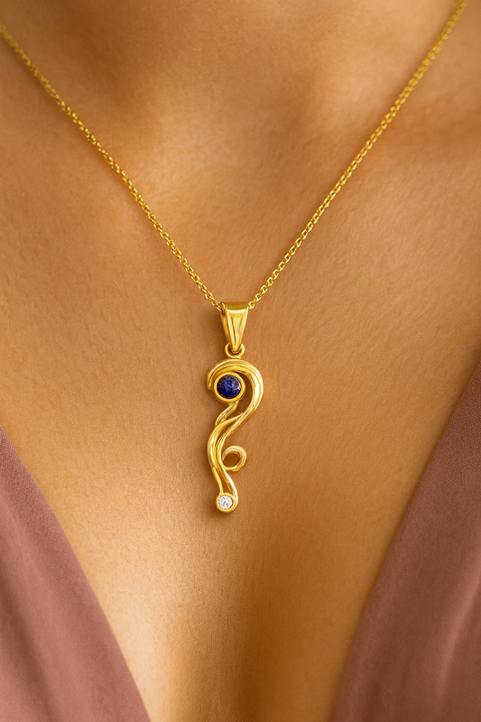 Gold necklace with a blue tanzanite gemstone pendant on a person's neck