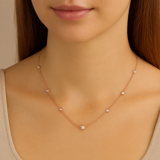 Rose gold necklace with small diamonds on a model against a neutral background
